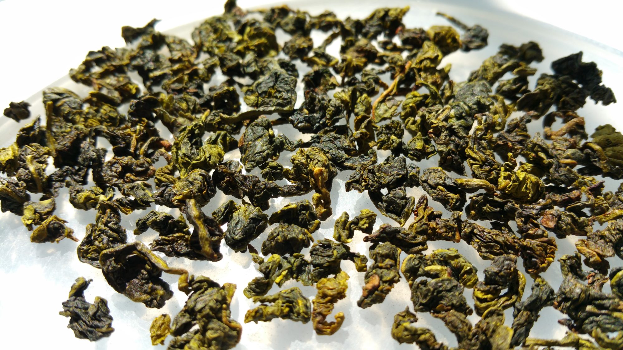 Get Started Drinking Tea - Oolong tea leaves on a white background