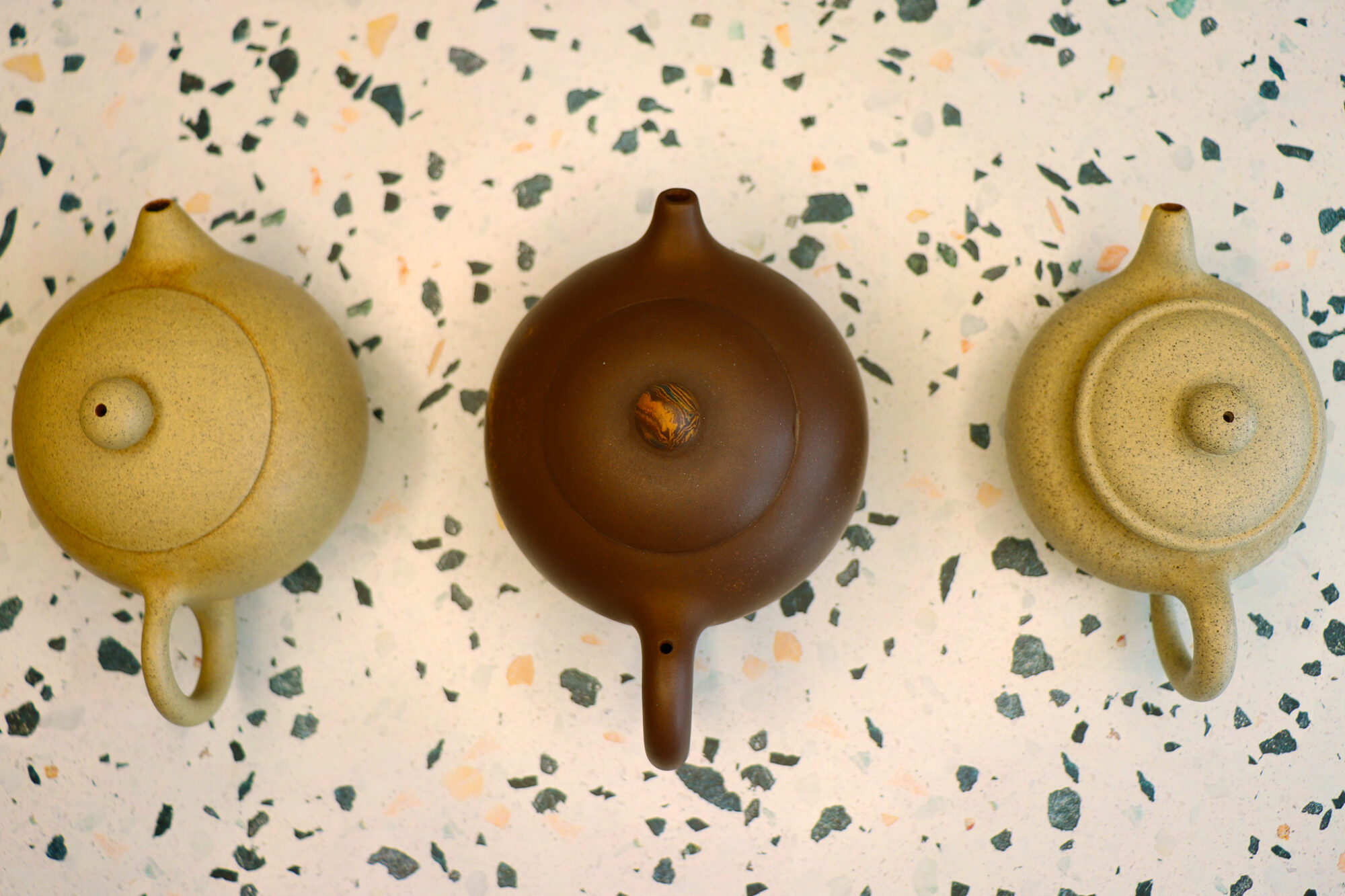 Overhead shot of three different teapots - Seasoning Yixing Clay Teapots - Everything You Need to Know About