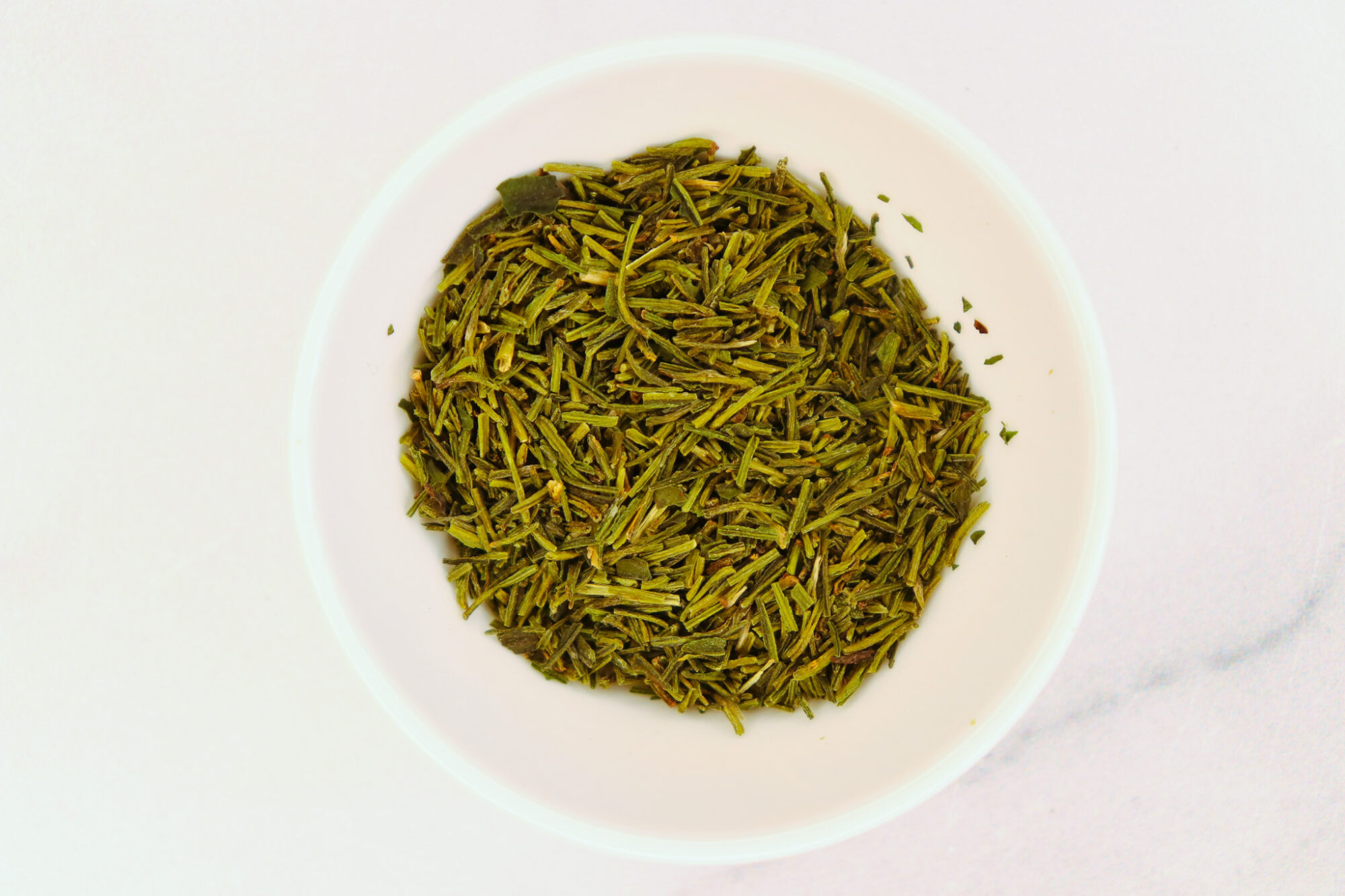 Kukicha tea leaves in a white bowl